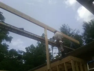 Carpenter setting a ridge beam over a new addition frame — Ice Dam Removal by Roofing Brothers in Rices Landing