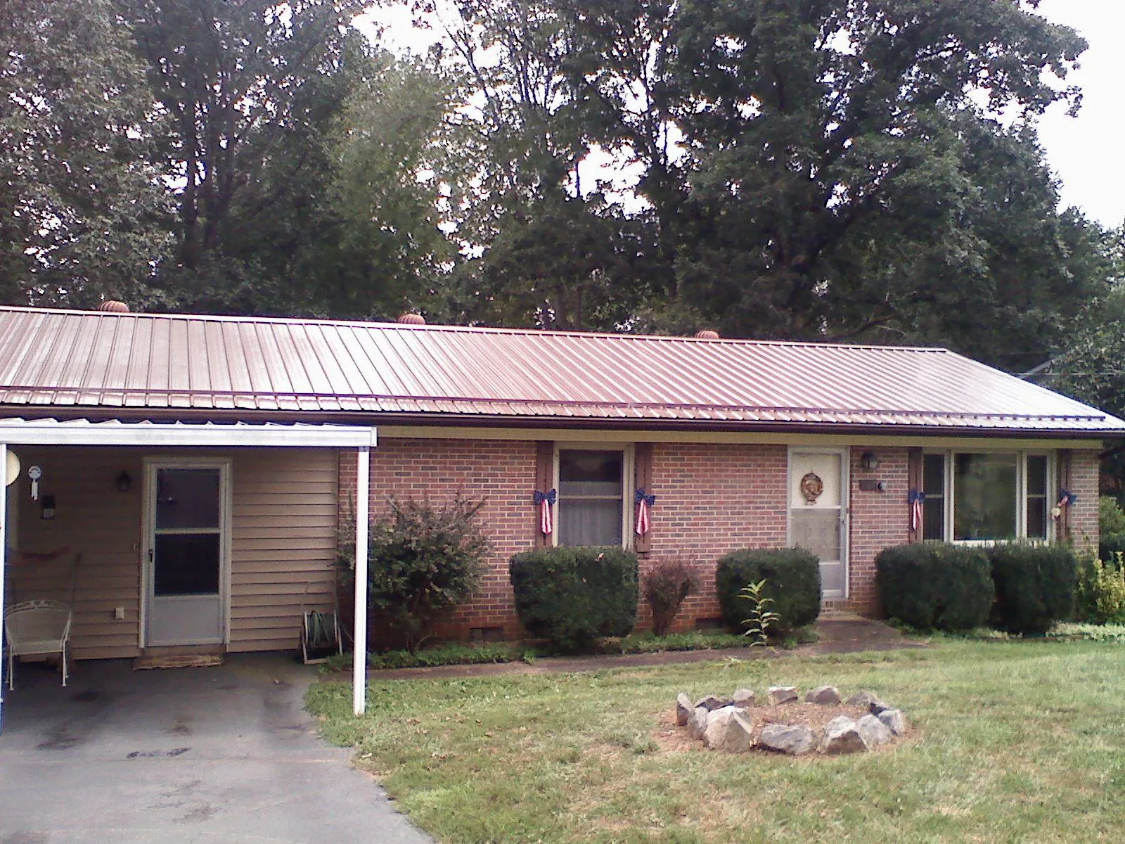 Bronze metal roof and carport on a brick ranch home — Roof Repair work by our crew in Rices Landing