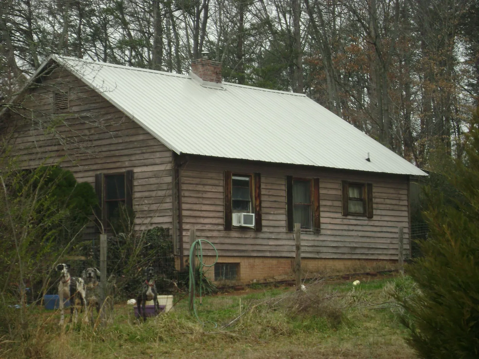 White metal roof on an old wood sided farmhouse, from a Metal Roof Installation job in Rices Landing